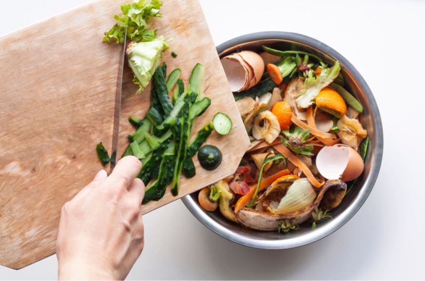 Une personne en train de verser des aliments dans une poubelle